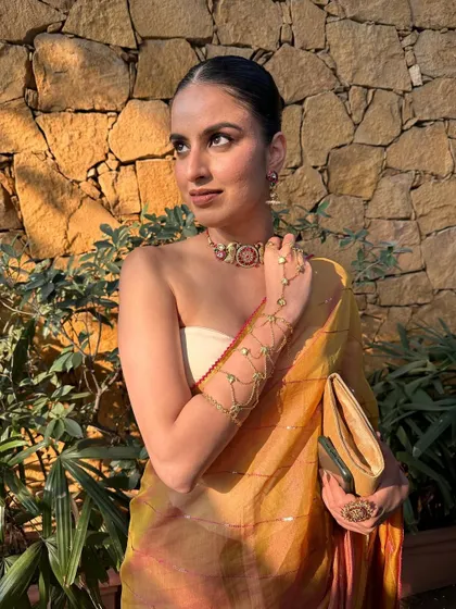 This look is all about effortless elegance, pairing fresh skin with bold, traditional jewelry for a balanced and modern aesthetic.