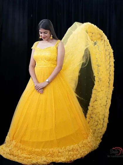 This yellow gown with a floral embroidered trail is a unique and beautiful piece available for rent.