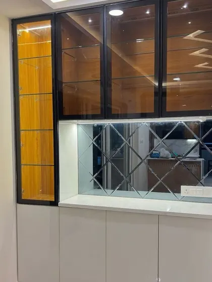 For this unit, I combined black-framed glass cabinets with a bevelled mirror backsplash. The mirrors reflect light and make the space feel larger and more glamorous.