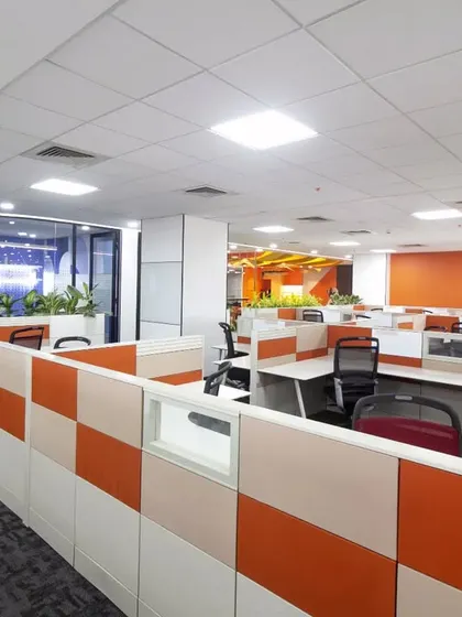 An open-plan workstation area at Scientific Games designed for productivity. We used a combination of neutral desks and colorful partition panels, complemented by motivational wall graphics like "Work Hard Stay Humble," to create a balanced and focused environment.