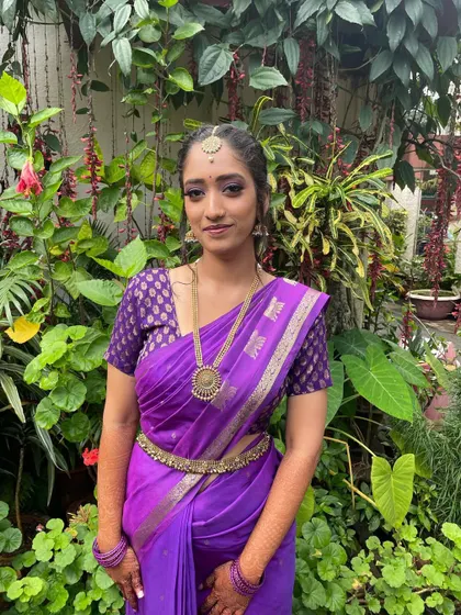The full look in her beautiful purple silk saree. The makeup is designed to last through long ceremonies while looking fresh and vibrant.