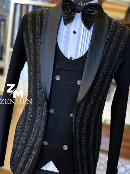 A three-piece black tuxedo with vertical stripes of shimmering beadwork. The double-breasted waistcoat adds a classic touch to this modern, sparkling design.