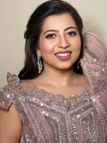A close-up portrait, highlighting the soft eye makeup and glowing skin.