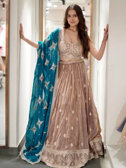 This muted gold lehenga with a pop of color from the teal dupatta is so chic. The star-motif on the dupatta adds a playful touch to this elegant outfit.