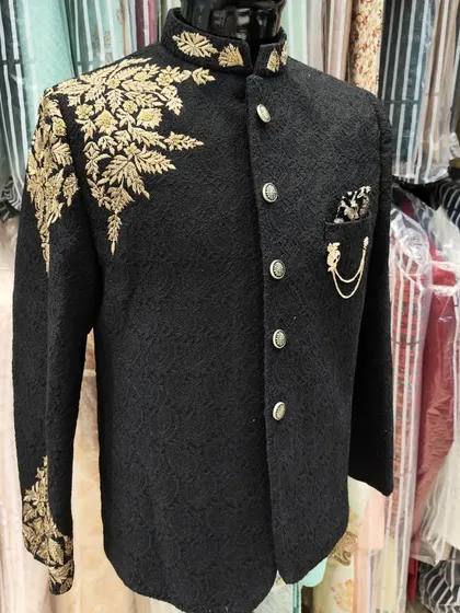 A black Jodhpuri suit is a timeless classic. I elevated this piece with intricate gold floral hand embroidery cascading down the shoulder and sleeve, making it a perfect choice for a formal reception or engagement party.
