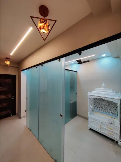 A dedicated pooja or prayer room, separated by frosted glass sliding doors. We design sacred spaces that are both beautiful and tranquil, respecting cultural and spiritual needs.