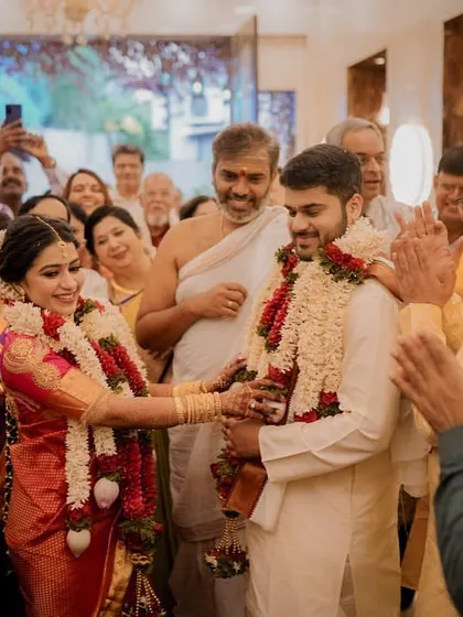 A joyous moment as the family blesses the new couple, their hands raised in celebration.