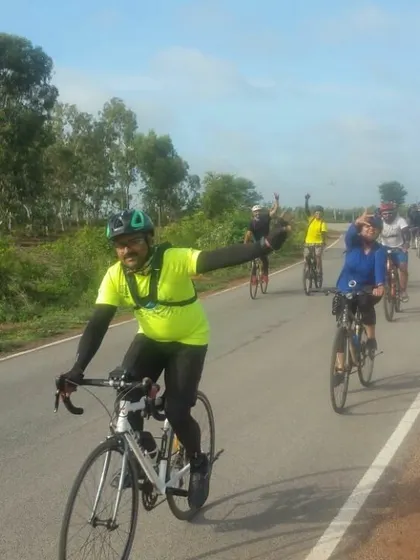 The group riding in formation on a paved road leading to a trail. It's smiles and waves all around.