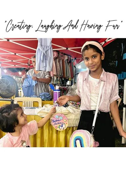 Creating, laughing, and having fun. These two sisters are enjoying our art stall, proudly showing off the personalized nameplate they created together.