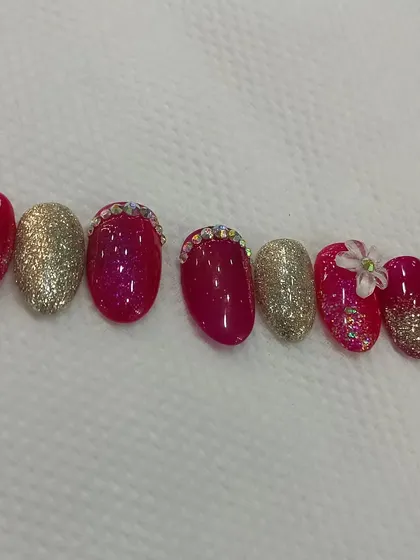 Another angle of the pink and gold press-on nails, showing the combination of glitter, chrome, and 3D art to create a multi-textured look.