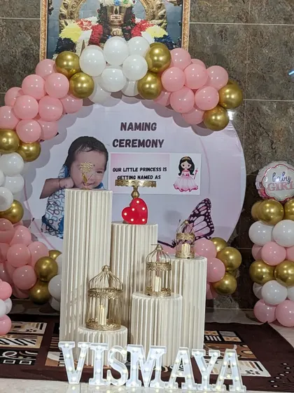 Another angle of the modern naming ceremony for Vismaya. This view shows the illuminated letters of the name in front of the decorative pedestals and balloon arch.