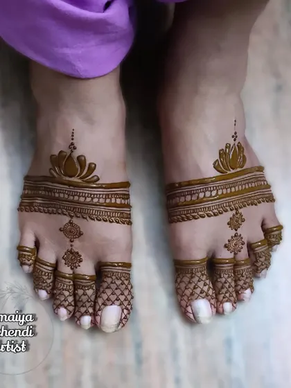 A simple and elegant feet henna design. This look features a lotus motif on the top of the foot with delicate netting on the toes.