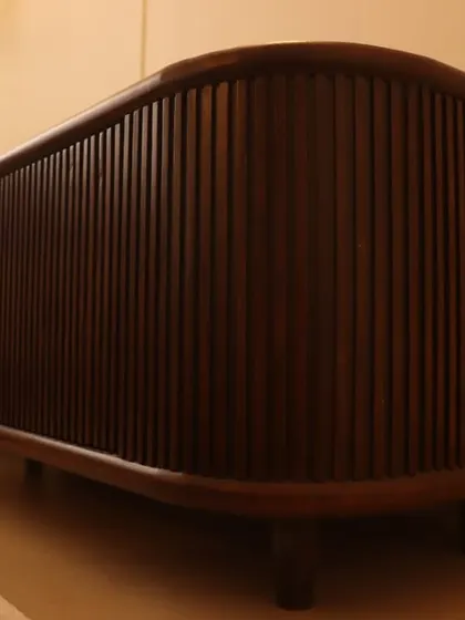If elegance had a personality, this console would be that mysterious, well-dressed stranger in a jazz bar. A custom-made console with fluted, curved dark wood.