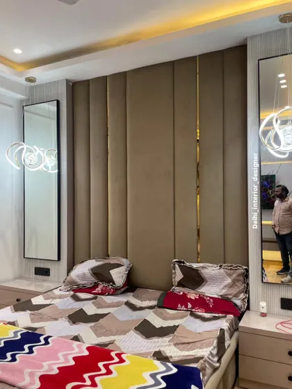 A side view of the bed, showing the texture of the upholstered headboard and the reflection in the bedside mirror.