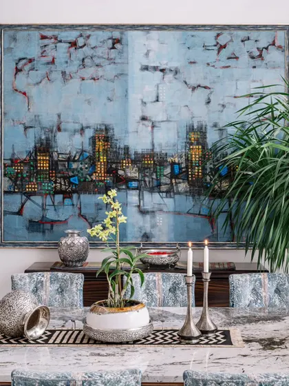 Art is central to my design philosophy. This large, abstract cityscape painting becomes the focal point of the dining area, its colors inspiring the palette for the rest of the room. It transforms a simple meal into a fine dining experience.