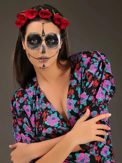 A direct portrait of the sugar skull Halloween makeup. The contrast between the dark, intricate makeup and the colorful floral dress is visually striking.