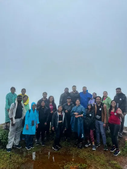 The team posing for a photo against a white wall of fog at the summit.