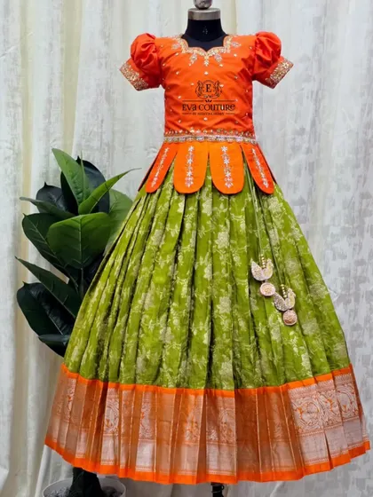 This lime green and orange Kanchi Pattu lehenga is so fresh and vibrant. The blouse has a unique petal-shaped peplum design.
