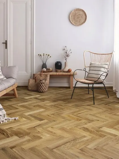 Here is another take on the herringbone pattern, this time with a slightly warmer wood tone. This flooring adds classic character and visual interest to this calm and neutral-toned room.