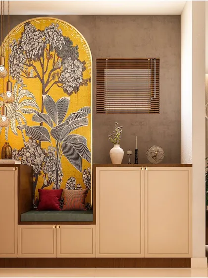 This entryway features a practical shoe cabinet with an integrated seating nook. The vibrant yellow and grey tree mural behind it adds a bold splash of color and personality.