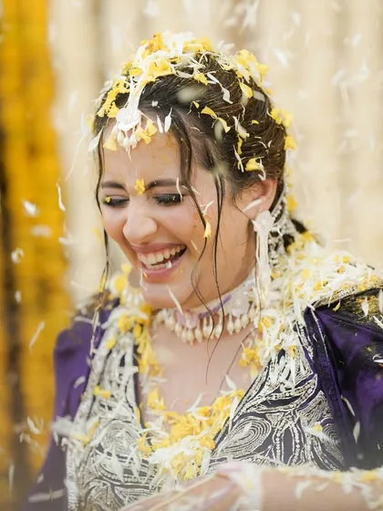 The bride's infectious laughter, a close-up shot capturing her happiness during the Haldi ceremony.