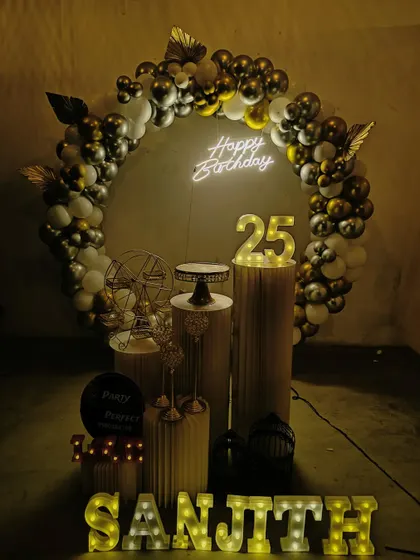 This moody and stylish setup was for a 25th birthday party. The black, silver, and gold balloon arch, combined with a neon sign and a light-up '25', creates a cool and celebratory vibe perfect for an adult milestone.