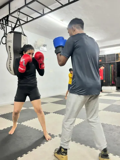 A female boxer practices her jab with a partner during a Thursday training session. Our academy is a place for everyone to learn the art of boxing.