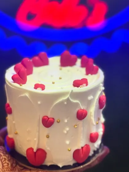 A mini tall cake decorated with red fondant hearts. This design is a smaller version of a full-sized cake, offering an elegant and romantic option for an intimate celebration.