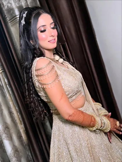 A side profile of the bride, highlighting the beautiful curls in her hair and the flawless finish of her makeup.