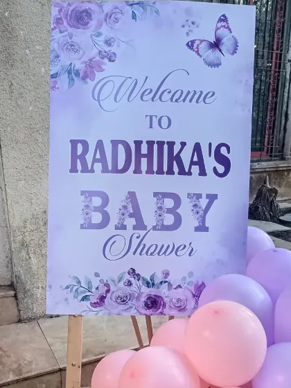 A close-up of a custom welcome sign for Radhika's baby shower. The purple floral and butterfly design was created to match the party's overall theme.