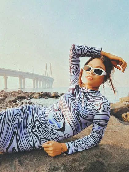 A relaxed, sun-kissed portrait on the rocks. This shot captures a moment of effortless cool.