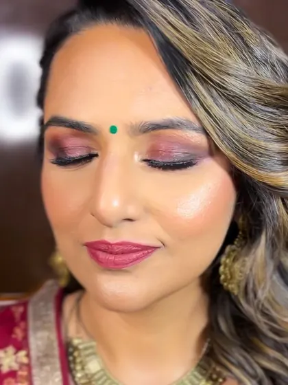 A close-up of this beautiful party makeup. The shimmery maroon and gold eyeshadow adds a touch of drama, while the highlighter gives her skin a beautiful glow.