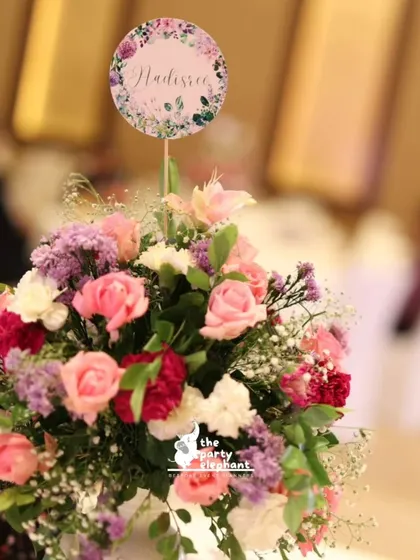 A close-up of a vibrant floral centerpiece for the butterfly fairy party. The mix of pink, purple, and red flowers adds a pop of color to the tables.