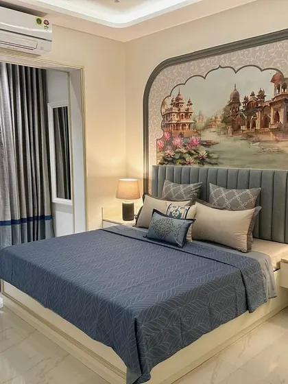 In this South Mumbai bedroom, I created a custom mural depicting a serene palace view, framed perfectly by an arch above the headboard. The design, paired with bespoke bedding and curtains, crafts a personal retreat rooted in regal Indian aesthetics.