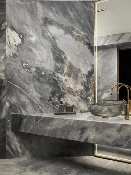 The powder bathroom in Project Acropolis makes a bold statement with dramatic grey marble. We used a single, powerful material to create a space that feels both luxurious and immersive, featuring a custom cantilevered vanity and a striking crystal-cut glass basin.