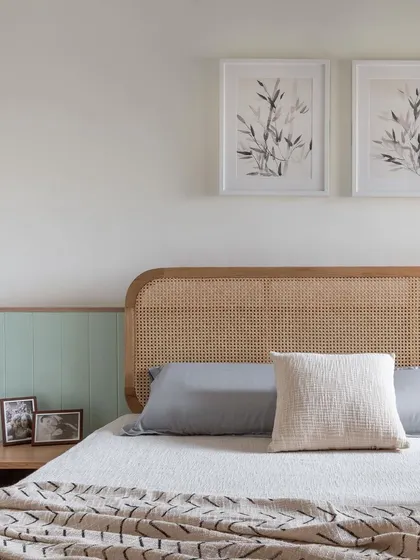 The primary room in 'Living life in colours' is designed with a mellow, subtle palette. The cane headboard and sage green paneling create a bright and calming atmosphere.