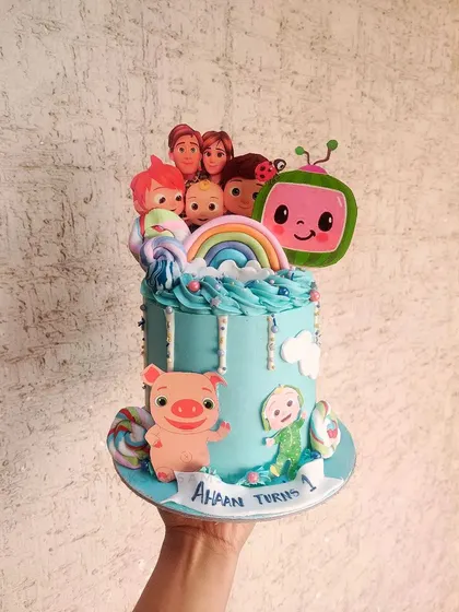 Another joyful Cocomelon cake, this one features the whole family and friends. The bright blue buttercream and rainbow make it a vibrant and happy centerpiece for a toddler's party.