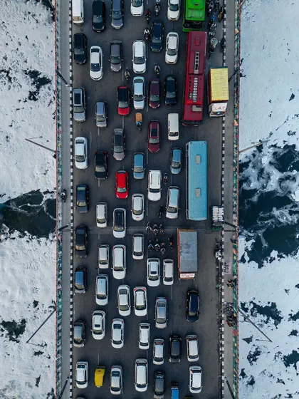 From above, the infamous Delhi traffic transforms into a work of art. This top-down aerial photo captures the chaotic yet colorful pattern of cars on a bridge over the Yamuna, finding a moment of organized beauty in the city's constant motion.