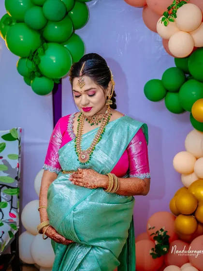 A quiet moment of reflection for the mother-to-be amidst the party. Her hand on her bump, she is the serene center of the celebration.