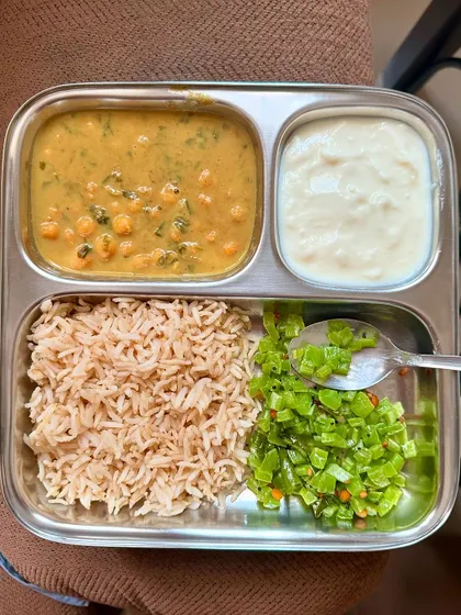 A comforting plate of brown rice with chana dal, sautéed French beans, and a side of curd.