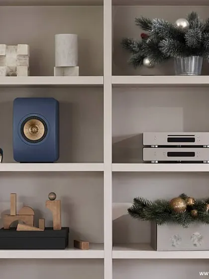 A KEF LSX II wireless speaker and stereo components elegantly displayed on a bookshelf. We believe in audio solutions that not only sound exceptional but also elevate your home's ambiance and design.