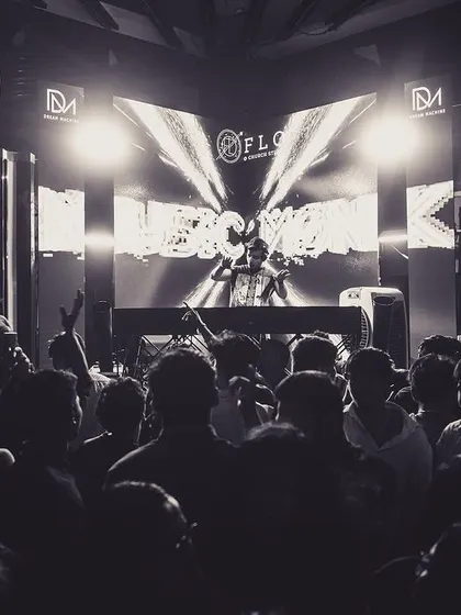 A powerful black and white shot of me on a large stage in front of a packed crowd. This image captures the scale and presence I bring to my shows.