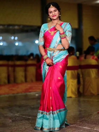 Archana at a festive event, her vibrant saree making her the center of attention.