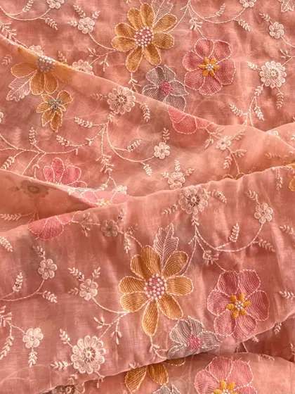 This peach-colored Mul Chanderi is brought to life with intricate floral embroidery. The soft texture and detailed threadwork make it a beautiful choice for festive wear.