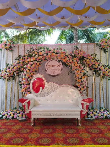 This Mehendi ceremony stage combines soft pastels with traditional design. The arch is decorated with beautiful pink and yellow roses, creating a dreamy and celebratory backdrop for the event.