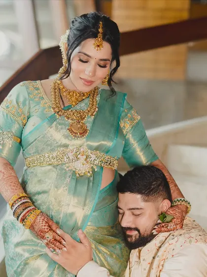 A tender moment captured forever. The makeup is soft and natural, ensuring the focus remains on the love and anticipation of this beautiful couple.