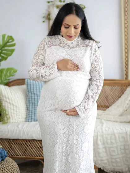 A beautiful solo portrait of a mom expecting twins, wearing a delicate white lace dress. We ensure every mom feels comfortable and beautiful.