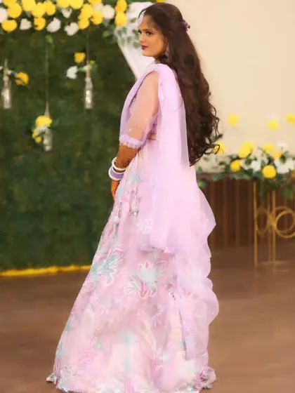 A back view of the bride, showing off her long, flowing hair and the elegant design of her lehenga.