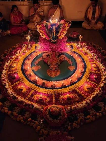 A family gathered for a Durga Deepa Namaskara pooja, with the entire setup beautifully lit.
