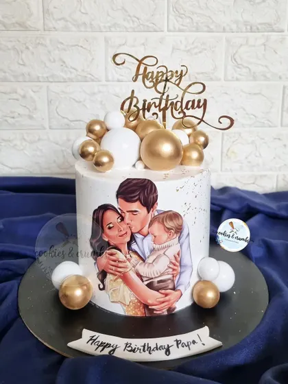 A heartwarming cake featuring an edible illustration of the family. This is a beautiful way to celebrate a husband and father, surrounded by gold and white spheres for an elegant touch.